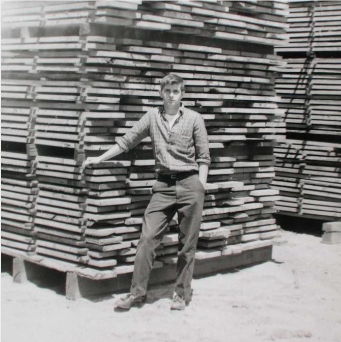 Archie MacDonald standing by some green on sticks lumber
